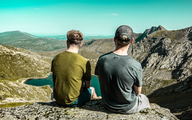 two people looking out at a mountain landscape