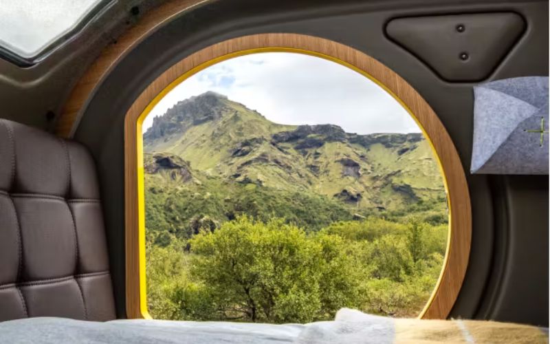 Mountain scene through an open Mink camper door
