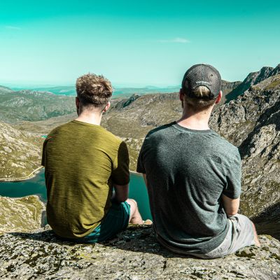 two people looking out at a mountain landscape